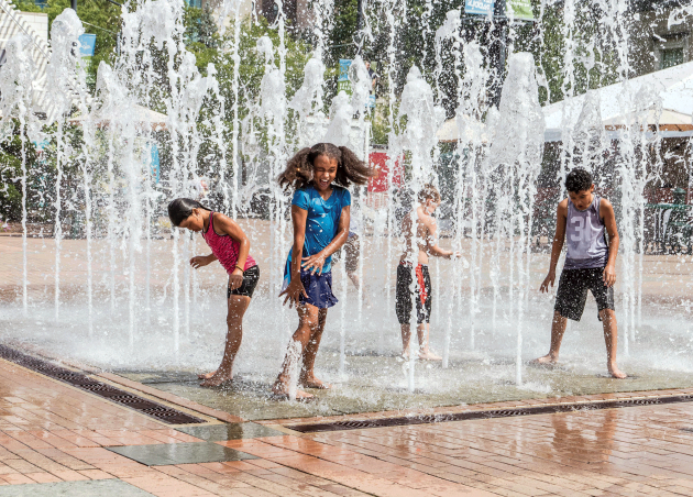 a group of kids playing in a water fountain