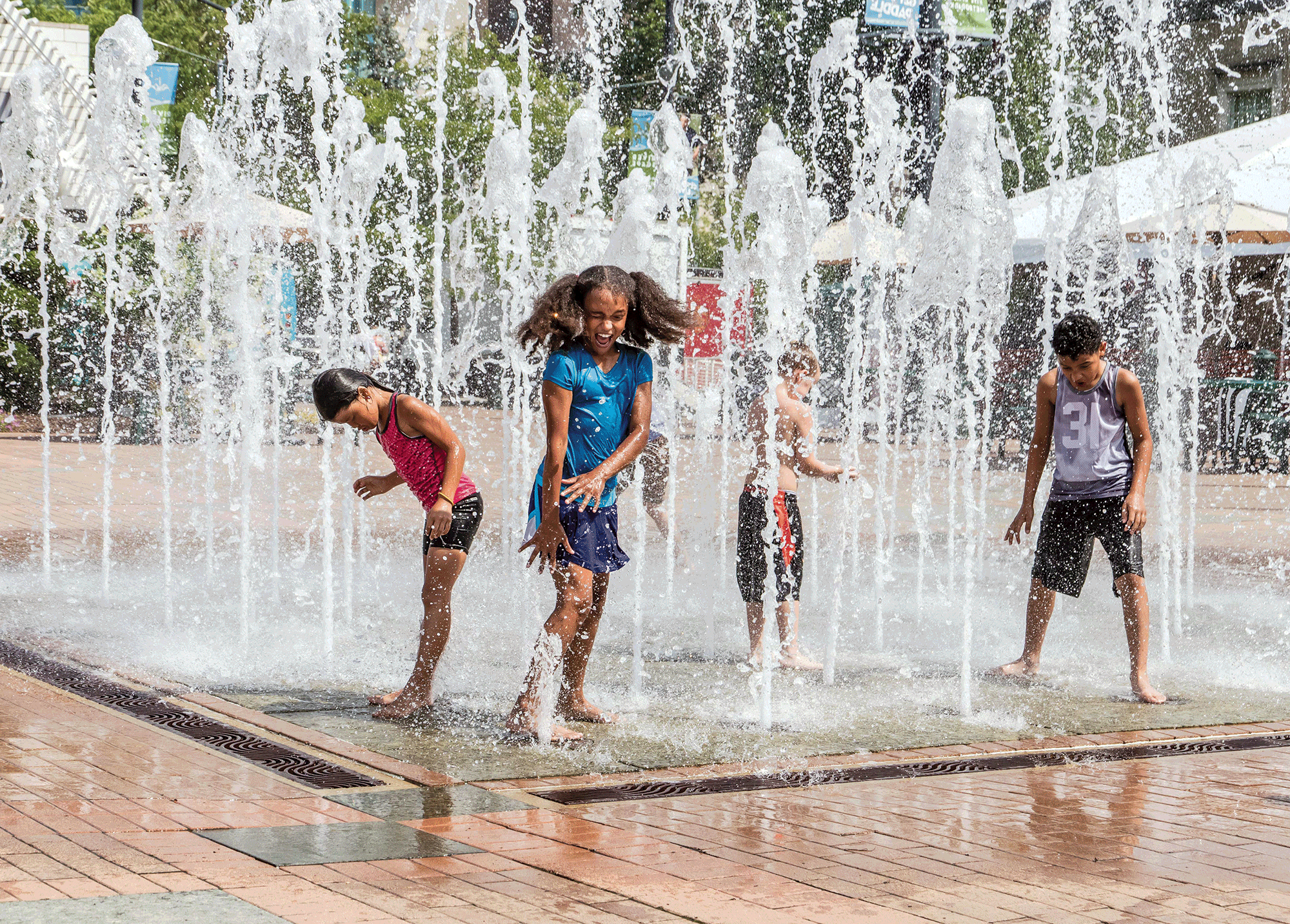 a group of kids playing in a water fountain