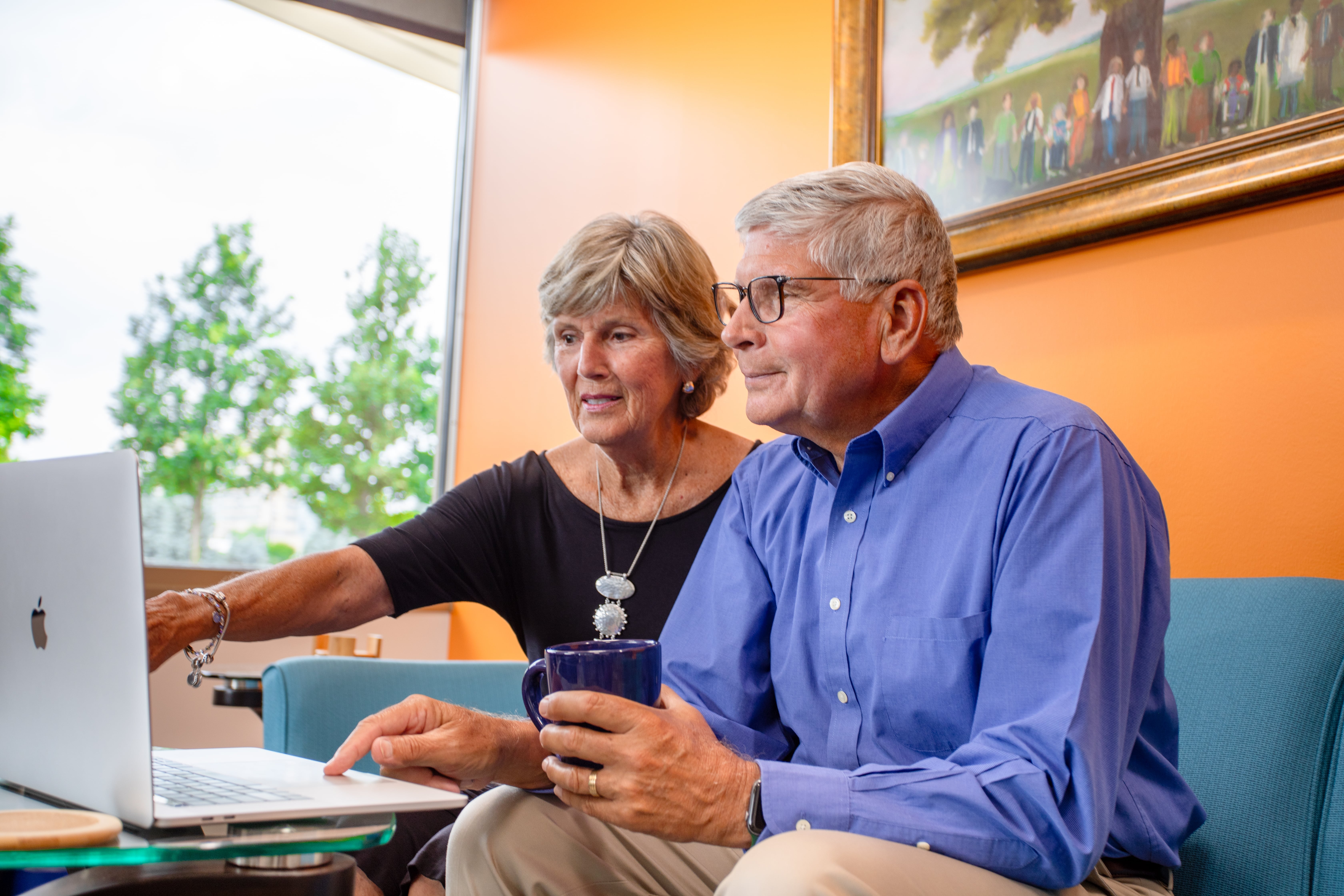 two people looking at a laptop